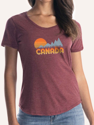 Woman wearing ladies burgundy red camping t-shirt with CANADA, sunset, mountains, canoe, and trees - Made in Canada by Choose Canadian Apparel Co