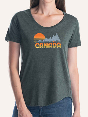 Woman wearing ladies forest green camping t-shirt with CANADA, sunset, mountains, canoe, and trees - Made in Canada by Choose Canadian Apparel Co