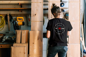 Trades woman in shop wearing Made in Canada T-shirt with Maple Leaf and Build Local Buy Local slogan