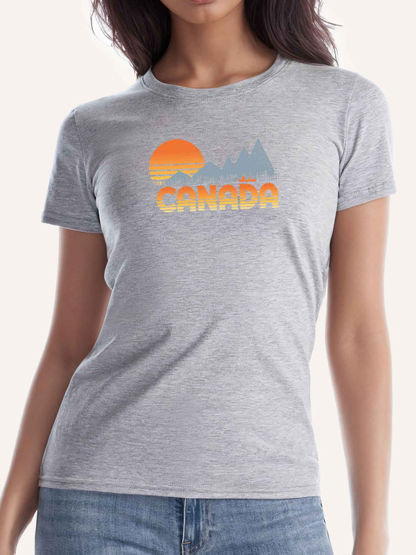 Woman wearing light grey camping t-shirt with CANADA slogan and orange sunset, mountain, trees and canoe graphic - Made in Canada by Choose Canadian Apparel Co