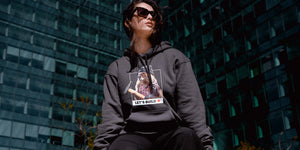 Woman wearing charcoal hoodie with Beaver design and Let's Build Canada slogan